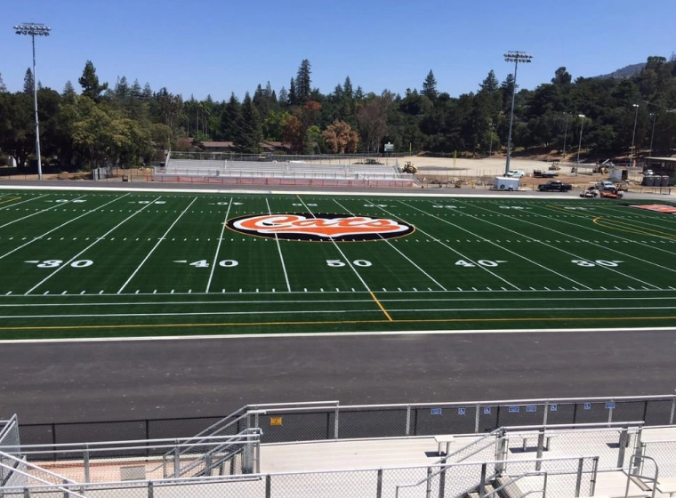 football field with some stripes and numbers and a cats logo in the middle