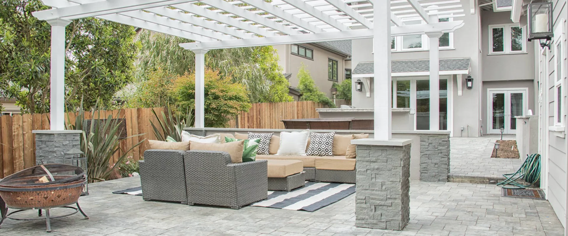 greyish house with an outdoor space with grey and beige sofas